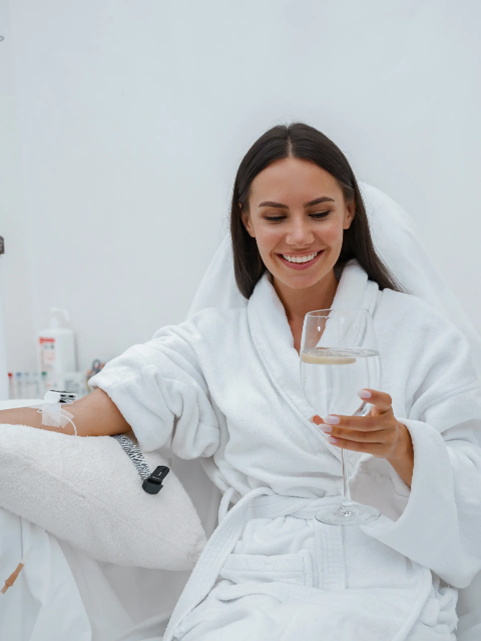 a woman in a white robe holding a glass of wine
