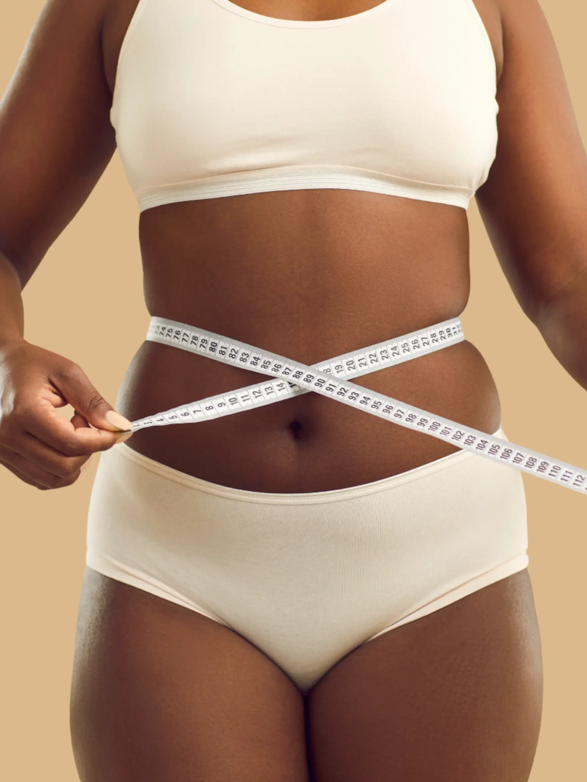a woman measuring her waist